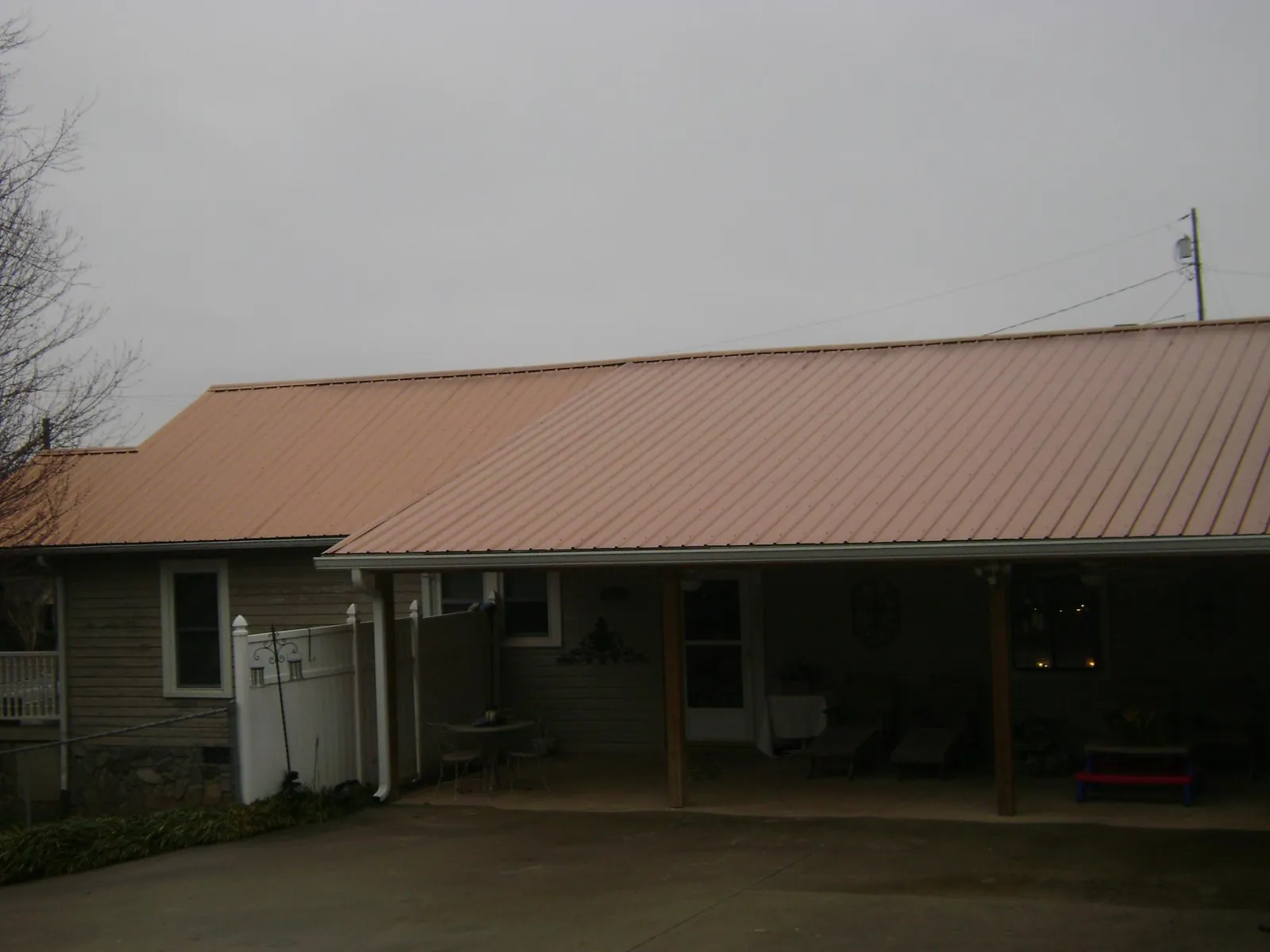Copper toned metal roof over a wide covered patio in Norway